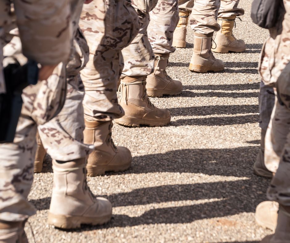 Stivali di soldati in uniforme desertica disposti in fila