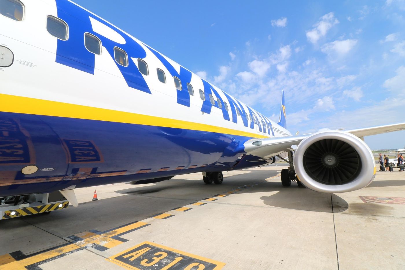 Primo piano di un aereo Ryanair sulla pista con il motore in evidenza, simbolo della compagnia e dei controlli sui bagagli