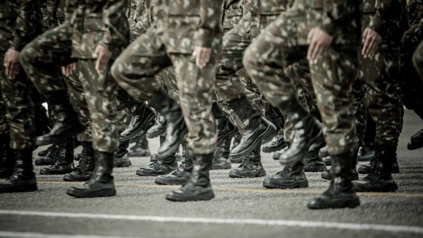 Truppa di soldati in uniforme mimetica durante una marcia