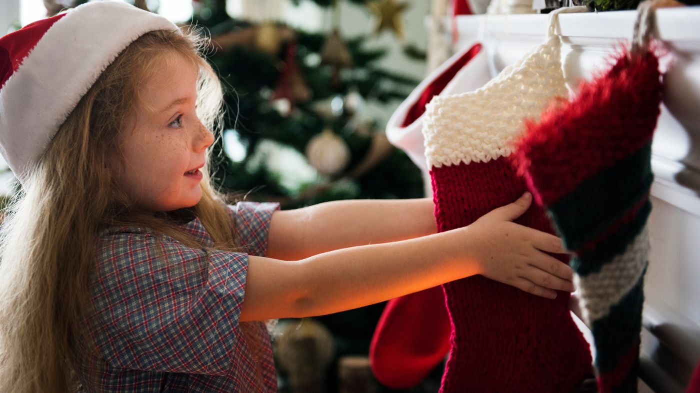 bambina che cerca i regali nelle calze