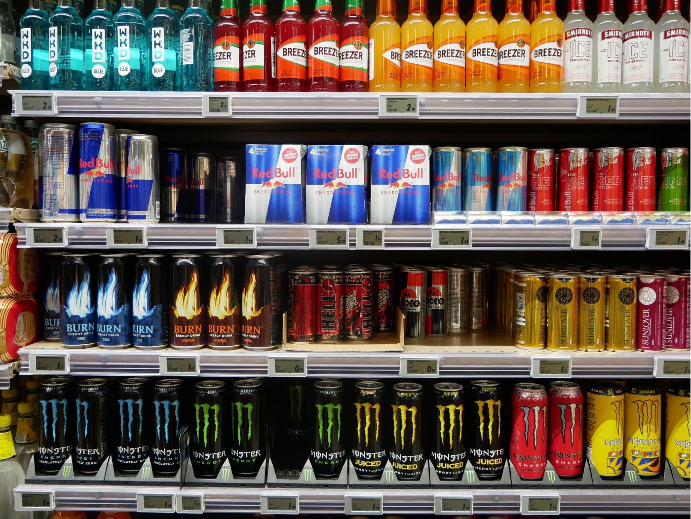 Scaffali di un negozio con lattine di energy drink di varie marche