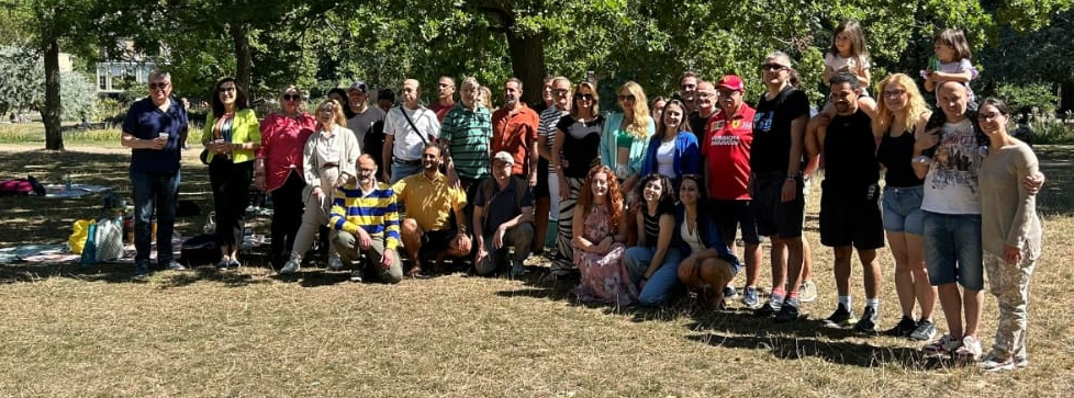 Gruppo di partecipanti al Picnic di Ferragosto a Walpole Park, Londra, riuniti e sorridenti