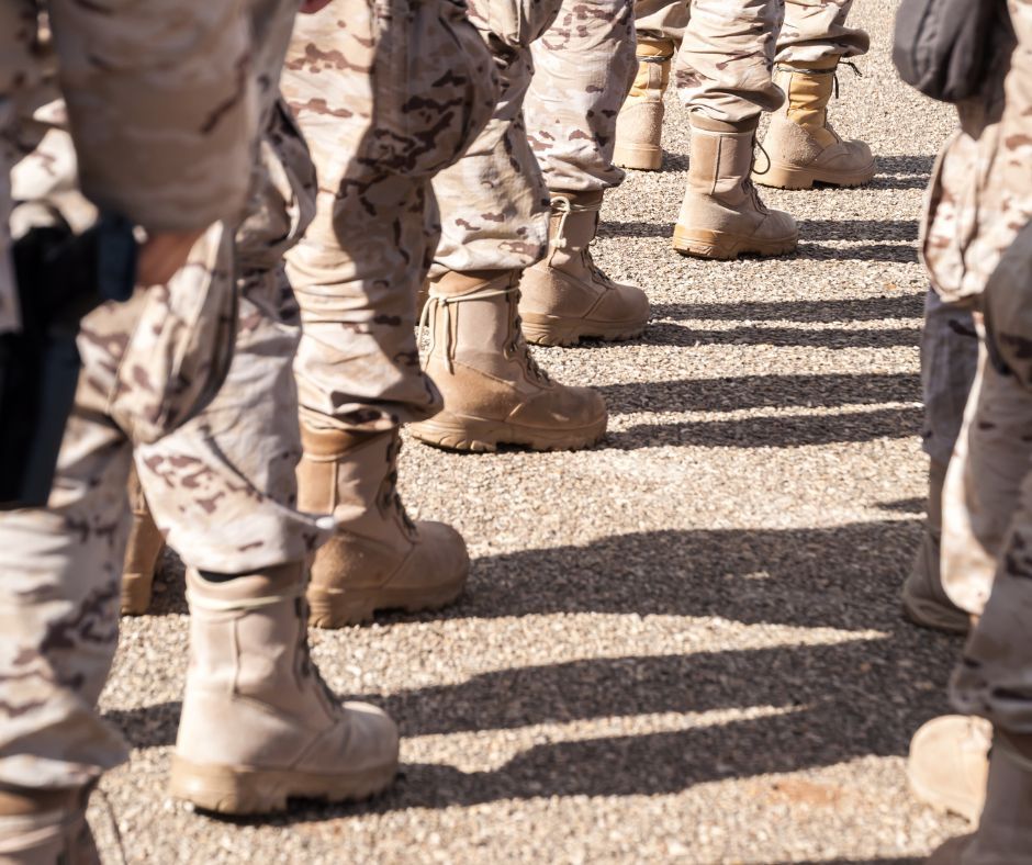 Stivali di soldati in uniforme desertica disposti in fila