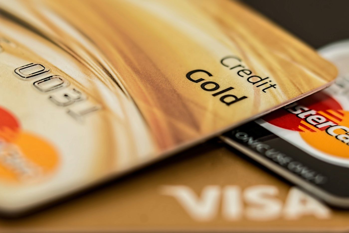 Dettaglio ravvicinato di carte di credito dorate sovrapposte, che richiamano il concetto di patrimonio e finanza