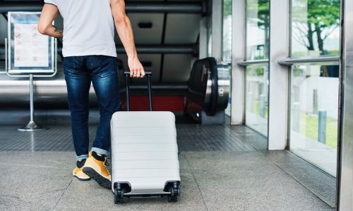 uomo con valigia per tornare in Italia