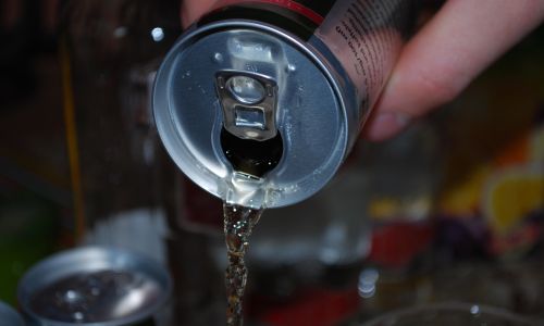 Una lattina di energy drink mentre viene versata, primo piano