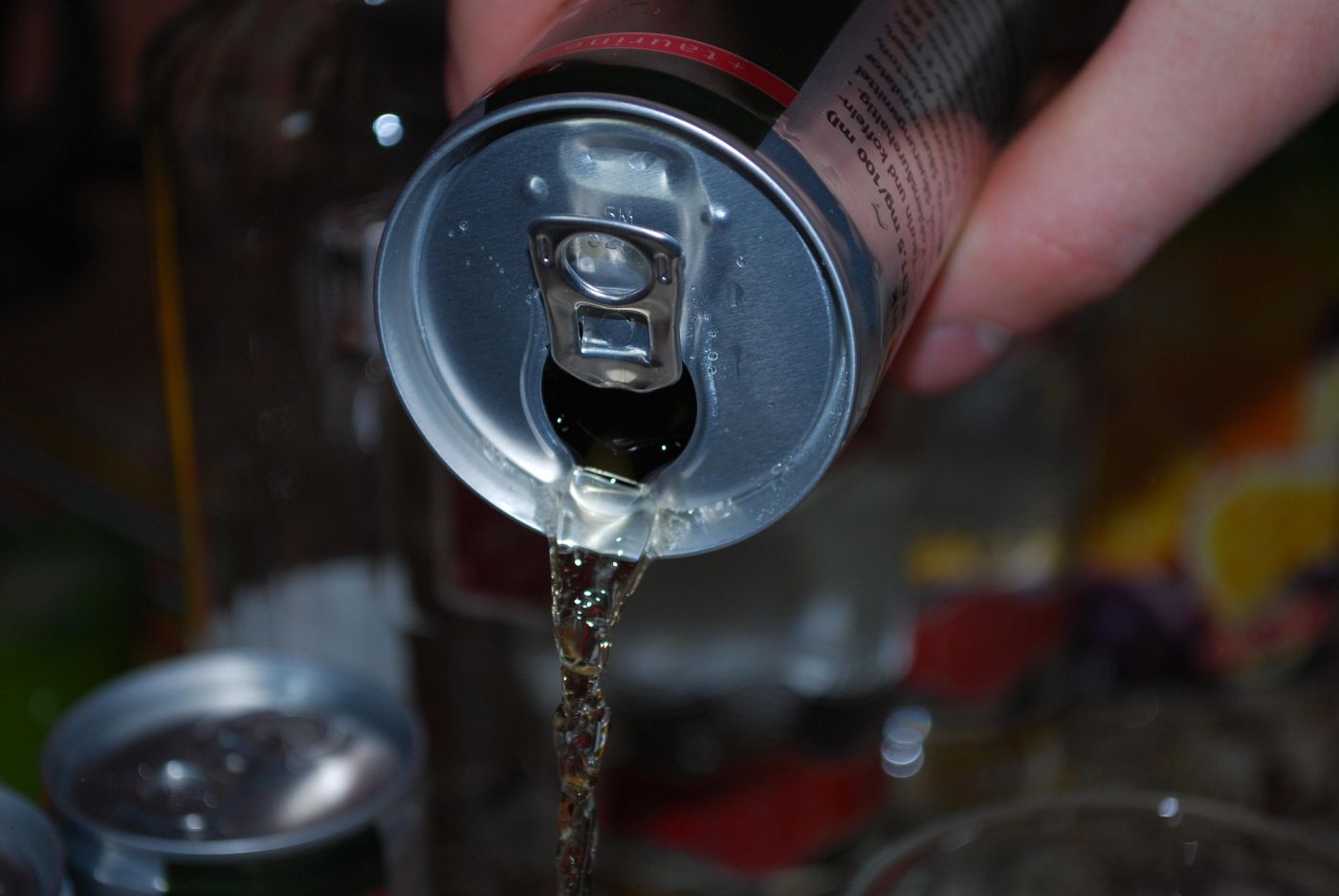 Una lattina di energy drink mentre viene versata, primo piano